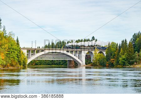 Kouvola, Finland - 18 September 2020: Autumn Landscape Of Bridge With Moving Old Steam Passenger Tra