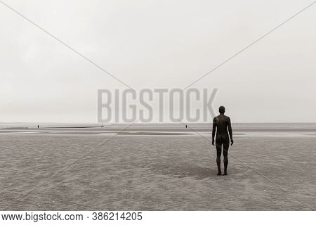 LIVERPOOL, UK - FEB 23, 2020: Antony Gormley's Another Place artwork on beach in England in United Kingdom