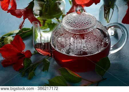 Hibiscus Tea In A Glass Transparent Teapot, And Blossom Flower