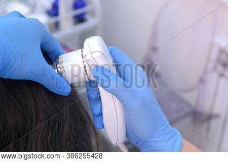 Doctor Trichologist Examines Woman Patients Hairs Using Trichoscope In Clinic, Closeup Hand View. Ru