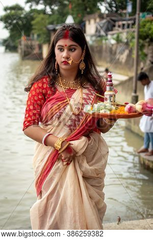 Portrait Of Beautiful Indian Girl Wearing Traditional Indian Saree, Gold Jewellery And Bangles Holdi
