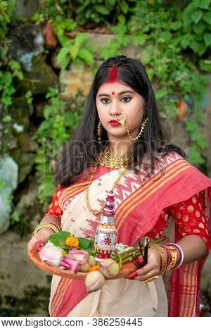Portrait Of Beautiful Indian Girl Wearing Traditional Indian Saree, Gold Jewellery And Bangles Holdi