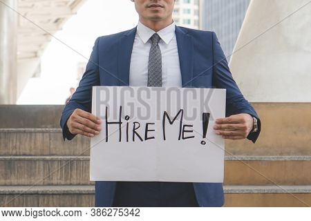 Asian Businessman Trying To Find Job And Showing Paper Sign To Tell Other People That He Looking For