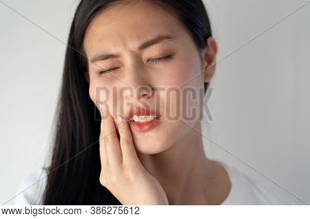 Teeth And Gum Problem Concept. Asian Young Woman Touching Cheek And Feeling Toothache And Pain Face 