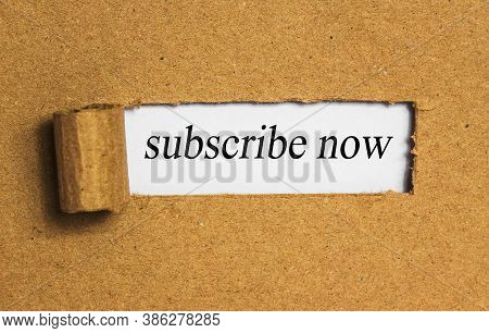The Text Subskribe Now Behind Torn Brown Paper