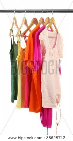 เสื้อผ้าต่าง ๆ บนไม้ hangers แยกต่างหากบนพื้นสีขาว