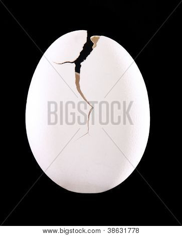 Huevos de cáscara blanca sobre fondo negro.Huevo roto.