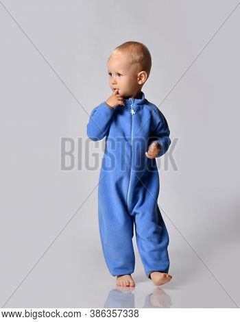 Full-growth Portrait Of Holding Forefinger At His Mouth Walking Going Towards Camera And Looking Asi