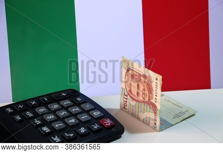 One Thousand Lire Of Italy Banknote With Black Calculator On The White Floor With Italia Flag Backgr