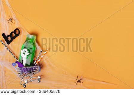 Halloween Shopping, Cart With Green Drink On Orange Background With Copy Space