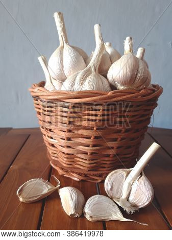 Closeup Garlic Are In The Wicker Basket On The Wooden Table.properties To Help Reduce Cholesterol.