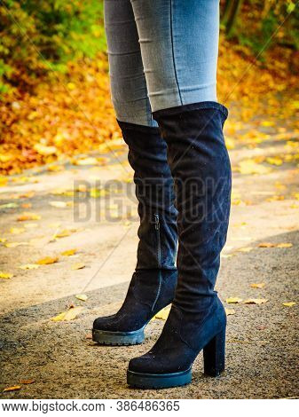 Woman Wearing Long Black Heeled Knee High Boots And Jeans. Autumn Fashion, Warm Footwear Boots.