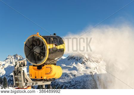 Operating Artificial Snow Cannon Near Piste Making Snowy Powder.ski Lift Ropeway On Hilghland Alpine