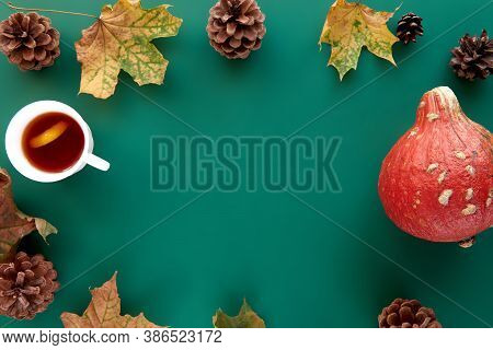 Autumn Composition. Frame Made Of Pumpkins, Dried Leaves, Pine Cones And Tes Cup Background. Templat