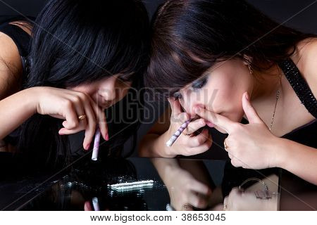 meninas estão cheirando cocaína (imitação). isolado em um fundo preto