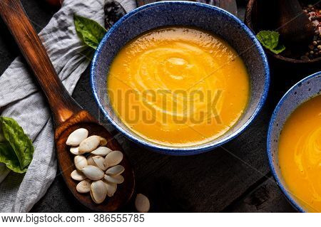 Plate Of Hot Pumpkin Soup On Black Wooden Table Close Up