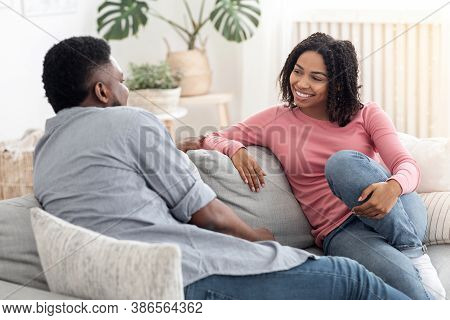 Communnication In Relationships. Loving Black Couple Chatting Together On Couch At Home, Enjoying We