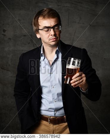 Portrait Of Middle-aged Man In Stylish Official Clothing Jacket And Shirt Looking Gravely At A Glass