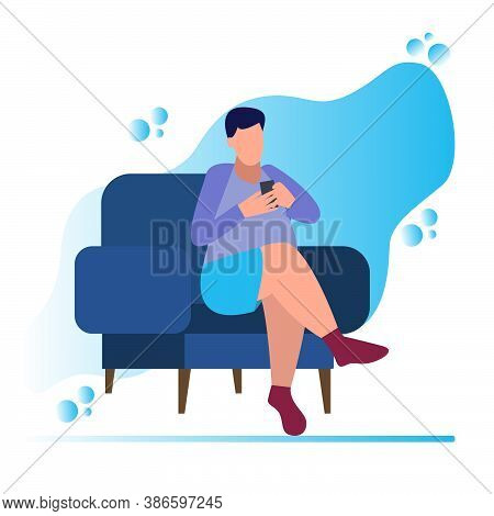 A Young Man Is Sitting In A Chair And Looking At The Phone, A Man Is Sitting With The Phone