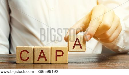 Businessman Puts Wooden Blocks With The Word Capa. Corrective And Preventive Action Plans. Business 