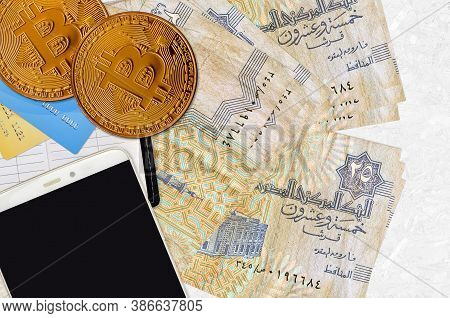 25 Egyptian Piastres Bills And Golden Bitcoins With Smartphone And Credit Cards. Cryptocurrency Inve