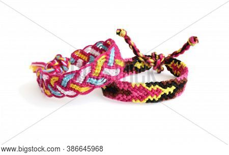 Selective Focus Of Two Tied Woven Friendship Bracelets With Bright Pink Pattern Handmade Of Thread I