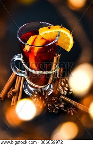 Mulled Wine Hot Christmas Drink With On A Dark Background. Orange Slices, Cinnamon Sticks, Christmas