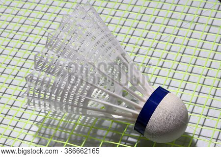 Plastic Shuttlecock Of Badminton Put On The Green Net Of Badminton Racket. It Is A Cork To Which Fea