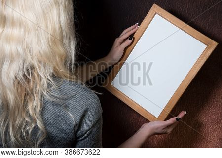 Partial View Of Young Blond Woman Holding Wooden Frame, Dark Background, Mockup, Blank Space