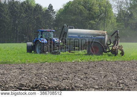 Sint Gillis Waas, Belgium, April 15, 2020, Farmer Is Fertilizing The Field With His Tractor