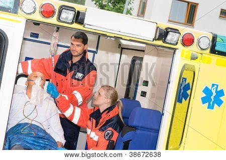 Paramédicos comprobación IV gotean a paciente en ambulancia tratamiento ayuda emergencia
