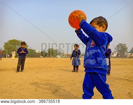 District Katni, India - January 17, 2020: Indian Preschool Male Kid Throwing Ball For Volleyball Gam