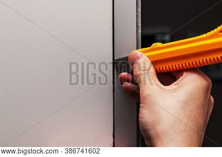 Close-up Of A Hand Opening The Panel With A Knife With A Retractable Blade