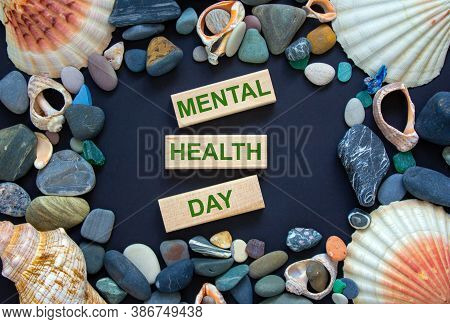 Text 'mental Health Day' On Wooden Blocks On A Beautiful Black Background. Sea Stones And Seashells.