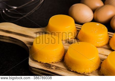 Delicious Quindins On Wooden Board, Traditional Brazilian Dessert Made With Egg Yolk, Sugar And Coco
