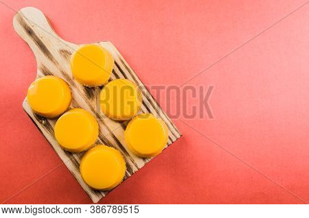 Delicious Quindins On Wooden Board, Traditional Brazilian Dessert Made With Egg Yolk, Sugar And Coco