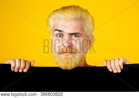 Man Holding Big Black Poster Isolated On Yellow Background