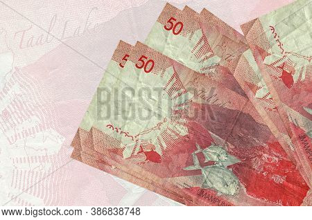 50 Philippine Piso Bills Lies In Stack On Background Of Big Semi-transparent Banknote. Abstract Pres