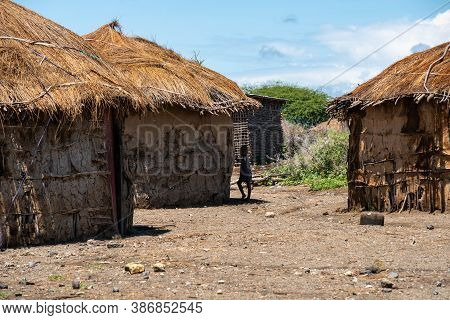 Engare Sero. Tanzania - January 2020: Indigenous Maasai Boy Near The Clay Hut In Traditional Village