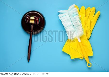 .rubber Gloves And Mallet On A Blue Background. Concept Of Litigation At A Cleaning Company.
