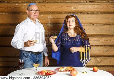 A Jewish Family, A Husband In A Kippah And A Wife In A Cape On Their Heads In Rosh Ashana Eat Challa