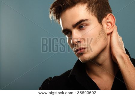 Moda giovane uomo in camicia nera, ritratto di moda sexy ragazzo cercando proprio sopra blu scuro