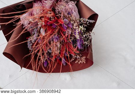 Beautiful Bouquet Of Lavender, Limonium And Feather Grass In Brown Packaging On White Snow