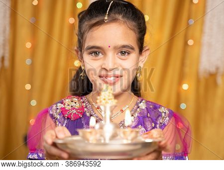 Pov Shot Of Cute Little Girl In Traditional Dress Doing Aarti Or Offering Light To God During Hindu 