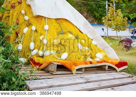 Pile Of Commercial Fishing Net On The Wooden Pallet At The Sandy Beach.