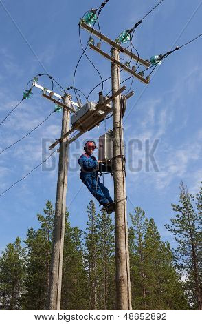 Electricista realizar mantenimiento en el reconectador de Torres de transmisión