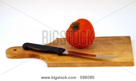 Tomaten mit einem Messer auf einen Teller