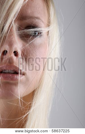 Portrait of a scared blond girl in studio