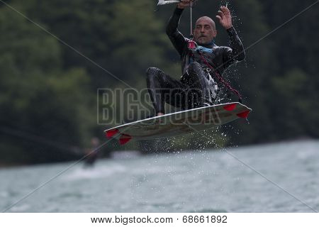 Professional  Kitesurfer Jumps Over The Water During Training On Lake Of Santa Croce