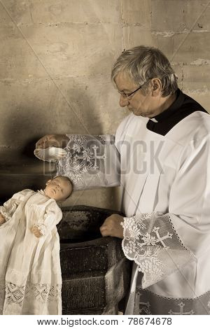 Sepia image of a vintage priest baptizing a baby